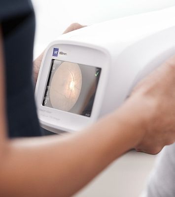 A clinician looking at results on a RetinaVue® 700 Imager.