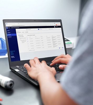 A biomedical engineer uses a remote device management tool to select multiple devices that need an update for faster update deployment.