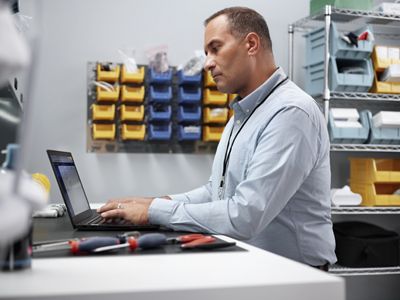 Man at a desk on his laptop in an IT room
