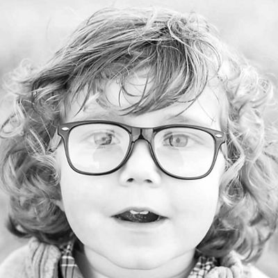 black and white portrait of a child wearing glasses