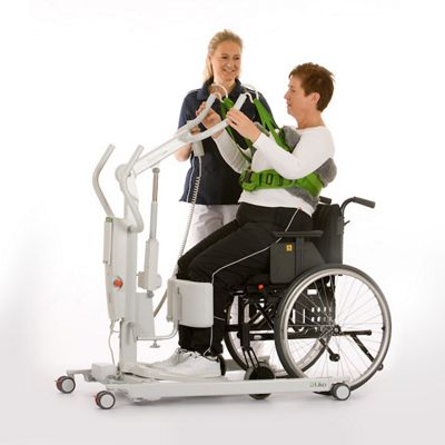 A clinician helps a female patient stand from a wheelchair using a SupportVest Lift Aid