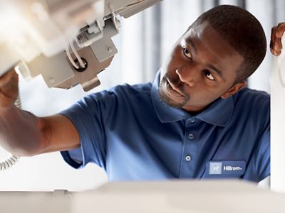 Ein Servicemitarbeiter von Hillrom inspiziert ein Hillrom Smart Bett