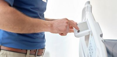 A biomedical engineer taps the Graphical Caregiver Interface (GCI) Touchscreen on a Centrella Smart+ Bed. 