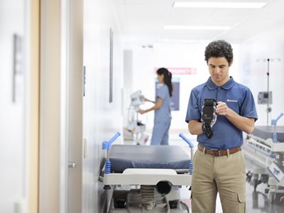 A Hillrom representative uses SmartCare Locating Technology to locate equipment from a hospital hallway