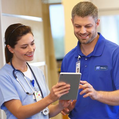 Nurse and Hillrom technician interacting with a tablet computer