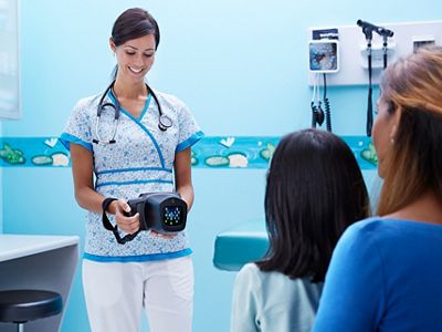 Primary care physician using Spot Vision Screener on young child