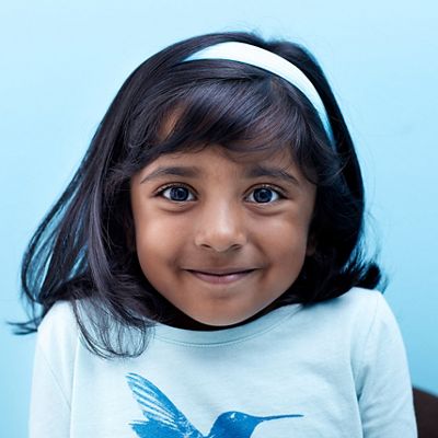 A female child smiles at the camera.
