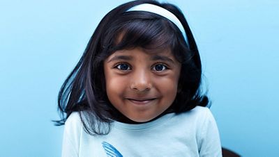 A patient smiles into the camera in a physician's office.