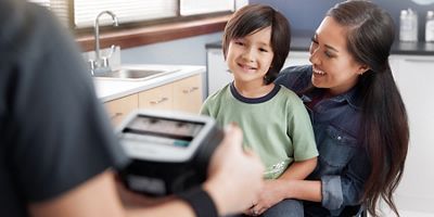 welch allyn spot vision screener exam with child on mothers lap