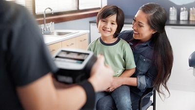 a nurse performs a pediatric eye exam using the Spot Vision Screener