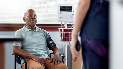 Un'infermiera torna dal paziente dopo che il dispositivo Spot Vital Signs 4400 ha eseguito un calcolo automatico della pressione arteriosa media.