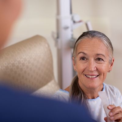 A female patient holds a Synclara mouthpiece in a care setting.