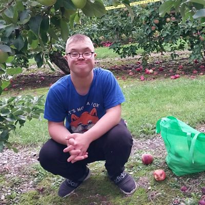 boy crouching down with glasses on 