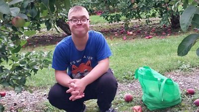 boy crouching down with glasses on