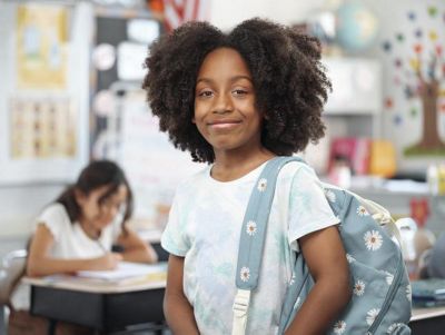 child with backpack in classroom