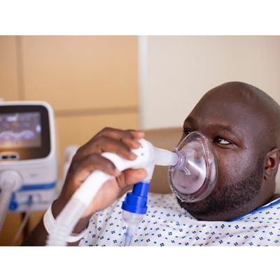 A patient receives OLE respiratory therapy from a Hillrom Volara System through a facemask interface.