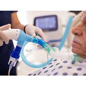 An older patient receives OLE respiratory therapy from a Hillrom Volara System through its tracheostomy interface.