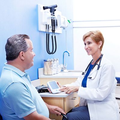 A physician reviews use of the Welch Allyn Home Hypertension Program with her patient in the office