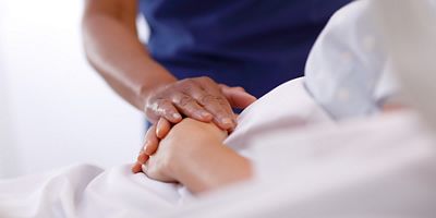 caregiver holding a patient's hand