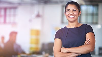 A professional woman smiles in a modern office environment