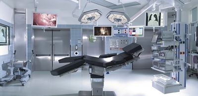 A modern operating room with surgical table, monitors, overhead lights and other equipment