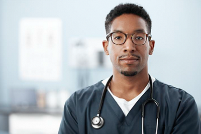 nurse with welch allyn stethoscope hanging around his neck with doctors primary office in the background