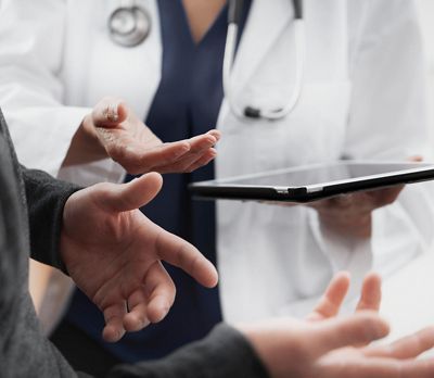 close up of doctor talking to patient with ipad in hand