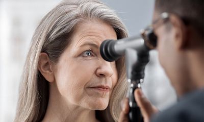 A clinician examines a patient's eye.