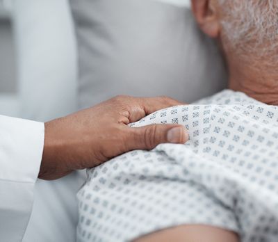 a doctor placing their hand on the shoulder of a patient