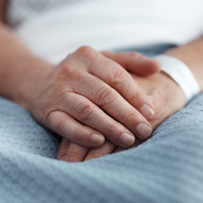 A close up of a patient's hands are shown with ID bracelet