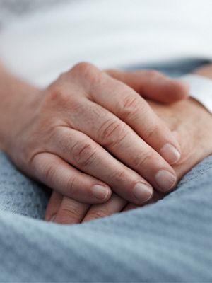 A close up of a patient's hands are shown with ID bracelet