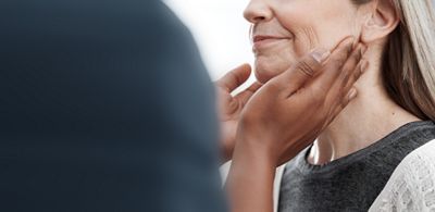 A clinician feels a patient’s neck and throat lymph nodes during a physical exam