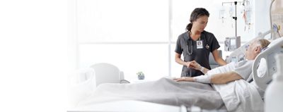 Nurse showing Voalte patient data on ipad to patient in Centrella Smart bed