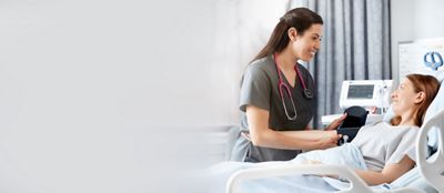 A clinician takes a patient’s blood pressure using the Connex Spot Monitor in a hospital setting