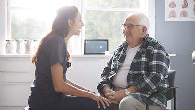 A clinician speaks with a patient while the Diagnostic Cardiology Suite ECG and Spirometry is seen in the background.