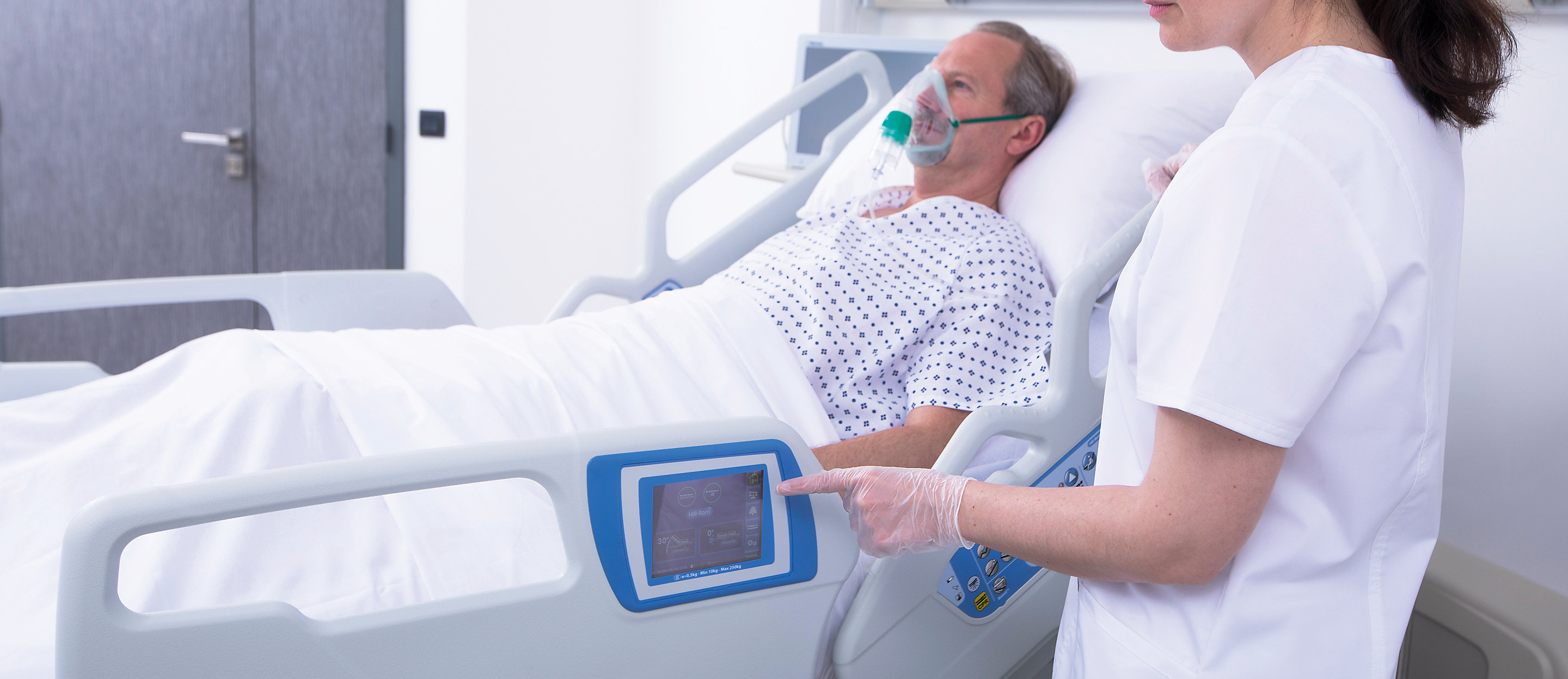 Ein Arzt tippt auf den Touchscreen des Hillrom 900 Accella Smart Bed