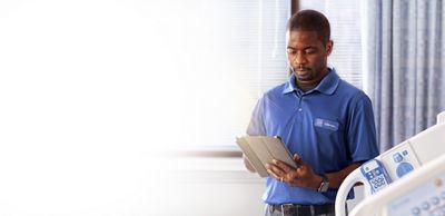 A technician uses a tablet while standing next to a CENTRELLA bed