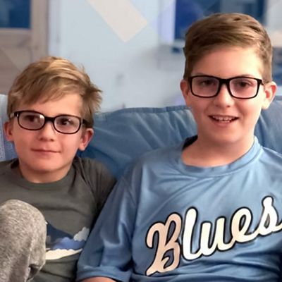 two children are shown smiling wearing glasses