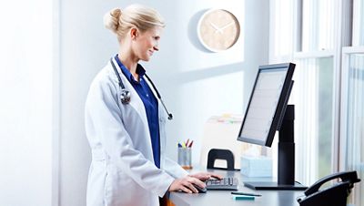 A clinician looking at a computer.