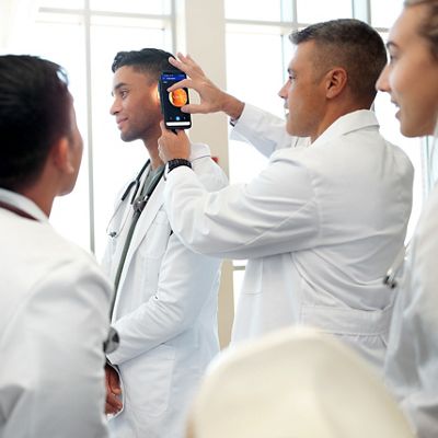 Medical student using pocket plus LED on patient