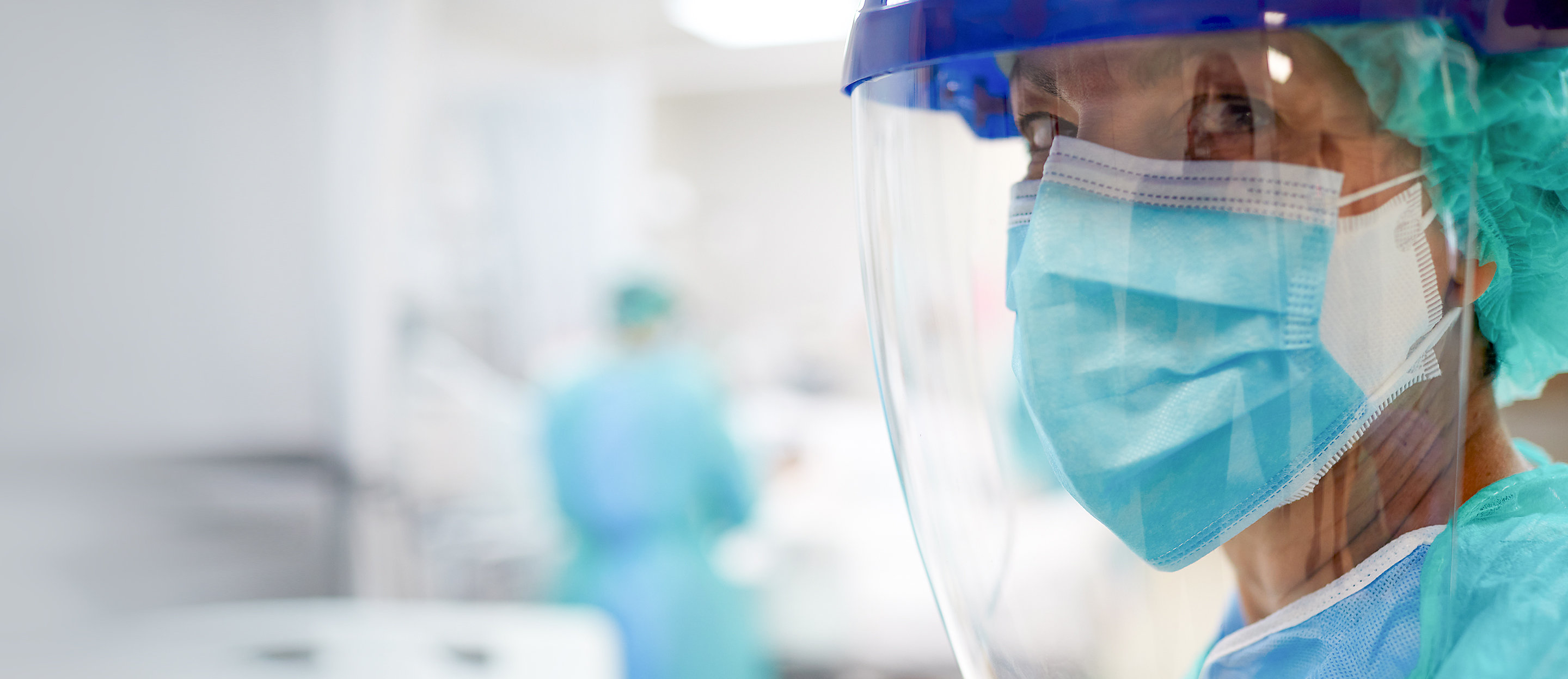 Close up view of a nurse or doctor wearing surgical mask and a face shield.