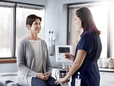 Female nurse and patient in doctor’s office having blood pressure checked using the Welch Allyn Connex Spot Monitor
