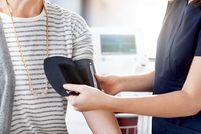A nurse positions a Welch Allyn blood pressure cuff on her patient’s arm in a primary care exam room