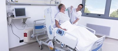 A clinician adjusts the Hillrom 900 Accella Smart Bed for a patient 