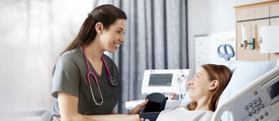 A clinician takes a patient’s blood pressure using the Connex Spot Monitor in a hospital setting