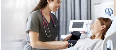 A clinician takes a patient’s blood pressure using the Connex Spot Monitor in a hospital setting