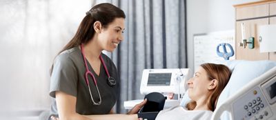  A clinician takes a patient’s blood pressure using the Connex Spot Monitor in a hospital setting