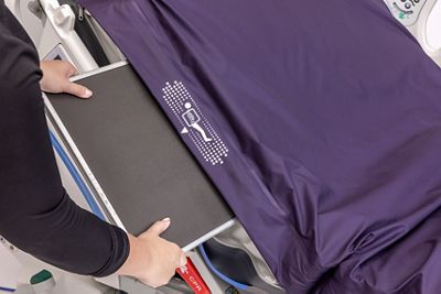 An x-ray cassette sleeve is shown being inserted into the Pro+ Surface