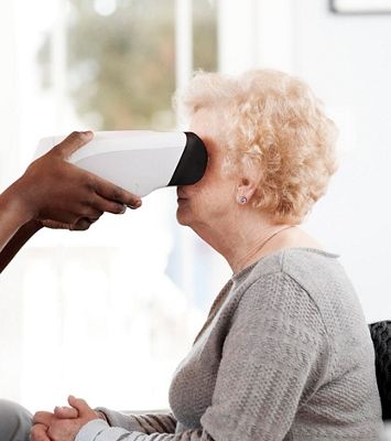 nurse using Welch Allyn RetinaVue 700 Imager on an older woman