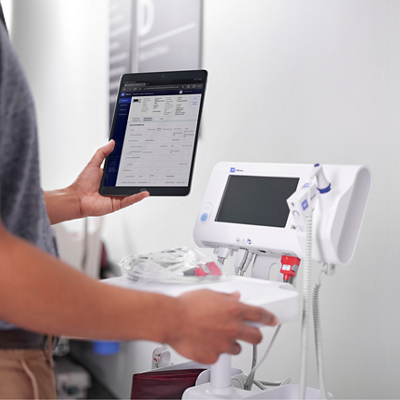 A clinician prepares to take a patient’s temperature using a Spot 4400 Vital Signs Device